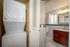 Chic apartment bathroom with elegant wood cabinetry, sleek tile accents, and a convenient in-unit laundry area.