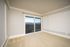 Bright and airy room featuring elegant molding, plush carpet, and large sliding doors opening to a scenic balcony view.