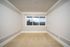 Bright, carpeted room with large window offering stunning mountain views, accented by elegant white trim.