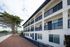 Charming three-story apartment building with elegant balconies and lush greenery, showcasing serene residential living.