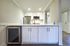 Modern kitchen space with sleek stainless steel appliances, elegant white cabinetry, and a spacious countertop.