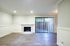 Elegant living room with a cozy fireplace, modern wood flooring, and large sliding glass doors opening to a private patio.