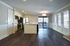 Elegant open-concept kitchen with modern appliances and spacious living area featuring large windows and stylish wood flooring.