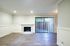 Bright living room with elegant laminate flooring, featuring a cozy fireplace and large sliding glass doors leading to a private outdoor space.