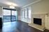 Bright and elegant living room with large windows, cozy fireplace, and access to a charming balcony.