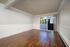 Bright and airy living room with elegant wooden flooring and sliding glass doors leading to a private balcony.