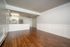 Spacious open-concept apartment with elegant hardwood flooring, modern kitchen, and stylish ceiling fan.