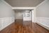 Inviting open-concept living area with elegant wood flooring, modern kitchen, and stylish white cabinetry.