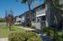 Charming residential apartment exterior with modern design, nestled in a lush green landscape, featuring inviting balconies and a serene atmosphere.
