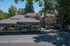 Charming apartment complex with covered parking, lush greenery, and welcoming architecture amidst a serene environment.