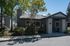 Charming, tree-shaded apartment exterior with modern design and inviting entrance, perfect for comfortable living.