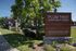 Charming Plum Tree Apartment Homes entrance sign, surrounded by lush greenery and a welcoming path.