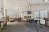 Inviting communal lounge space featuring a cozy fireplace, modern seating area with stylish chairs, and natural light from large windows, perfect for relaxation and social gatherings.