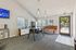 Chic communal lounge with modern furniture, stylish lighting, and a serene view of the outdoor pool area.