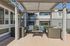 Charming outdoor patio featuring stylish wicker furniture under a modern pergola, ideal for relaxation and entertaining.