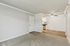 Bright and airy apartment interior with plush carpeting, sleek ceiling fan, and modern open-plan kitchen.