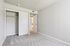 Bright bedroom with freshly carpeted flooring, ample closet space, and a sophisticated neutral palette.