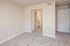 Inviting bedroom with plush carpet flooring and neutral wall tones leading to an en-suite bathroom.