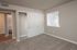 Inviting bedroom with plush carpet, large closet doors, and ample natural light from window blinds.