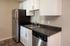 Contemporary kitchen with sleek stainless steel appliances, elegant white cabinetry, and rich dark countertops for an upscale feel.