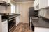 Modern kitchen with sleek black countertops, stainless steel appliances, and elegant white cabinetry, perfect for culinary creativity.
