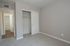 Bright, cozy bedroom with plush carpeting, a spacious closet, and modern neutral decor, perfect for creating a relaxing sanctuary.