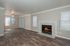 Inviting living room with elegant hardwood flooring, a cozy fireplace, and large windows offering ample natural light.