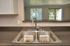 Modern kitchen with sleek double sink and pull-down faucet, featuring a pass-through window with scenic outdoor view.