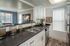 Modern kitchen featuring sleek countertops, stainless steel appliances, and abundant natural light for a warm, inviting space.