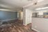 Modern open-concept living area featuring elegant wood flooring, a stylish kitchen with stainless steel appliances, and ample natural light.