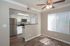 Modern apartment space showcasing a bright kitchen with stainless steel appliances, elegant wood flooring, and ample natural light from large windows.
