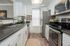 Modern galley kitchen with sleek stainless steel appliances, stylish dark countertops, and crisp white cabinetry.