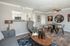 Modern living area featuring sleek grey furniture, a stylish open-concept kitchen, and an artistic dining space with unique decor.
