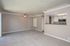 Bright and inviting open-concept living space with plush carpeting, modern ceiling fan, and sleek kitchen bar.