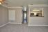 Contemporary apartment with open kitchen view, bright hallway, and plush carpeting, offering a cozy and modern living space.