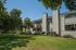 Charming apartment complex surrounded by lush greenery, showcasing spacious balconies and modern architecture.