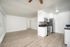 Bright and spacious open-concept living area featuring modern kitchen with stainless steel appliances and sleek wood flooring.