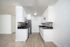 Modern kitchen with sleek white cabinetry, stylish backsplash, and stainless steel appliances, offering a bright and spacious cooking area.