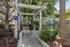 Inviting apartment entrance with elegant pergola, surrounded by lush greenery and vibrant landscaping.