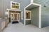 Inviting apartment entrance showcasing modern architecture with large windows and a clean, welcoming entryway.
