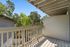Charming apartment balcony with a scenic view of lush green trees, offering a serene outdoor space.