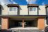 Charming townhouse exterior with classic brick accents, large windows, and covered parking, offering a welcoming and secure residence.