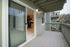 Inviting balcony view with sliding glass door leading to a modern kitchen, perfect for outdoor relaxation and entertaining.
