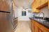 Modern kitchen with stainless steel appliances, elegant wooden cabinetry, and a window offering natural light.