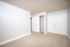 Bright and spacious bedroom with double closets and plush carpet, offering ample storage and sleek white doors for a modern touch.