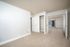 Bright and spacious bedroom with soft carpeting, dual closets, and a private balcony view.