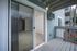 Inviting apartment balcony with sliding glass door leading to a bright, carpeted living area, providing outdoor relaxation and elegant indoor ambiance.