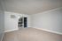Bright and airy room with neutral tones, featuring a chic sliding door leading to a private balcony with tranquil views.