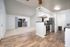 Elegant apartment interior showcasing an open-concept design with modern kitchen, sleek stainless steel appliances, and bright living area with sliding glass doors leading to a private patio.
