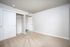 Bright, carpeted room with a spacious closet and sleek white doors, perfect for versatile living space.